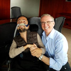 A photo of Dr. Victor Pineda and James Thurston clapsing hands and smiling. 